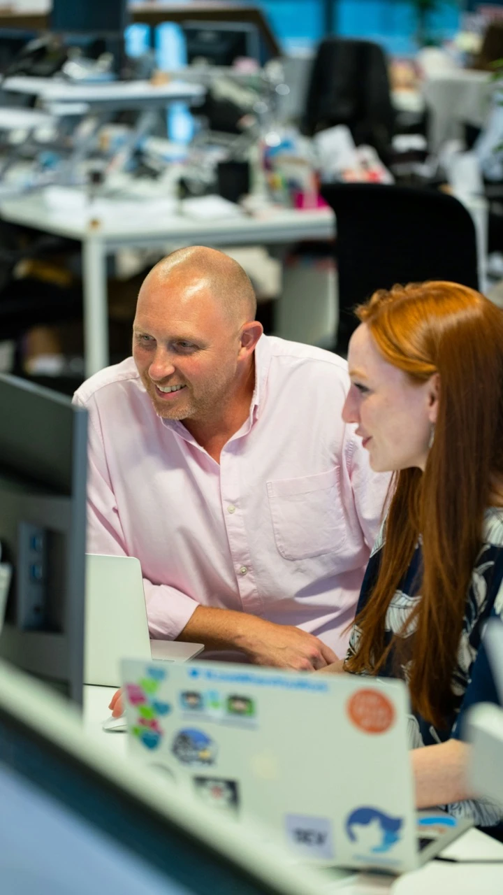 A man and a woman looking at a computer screen